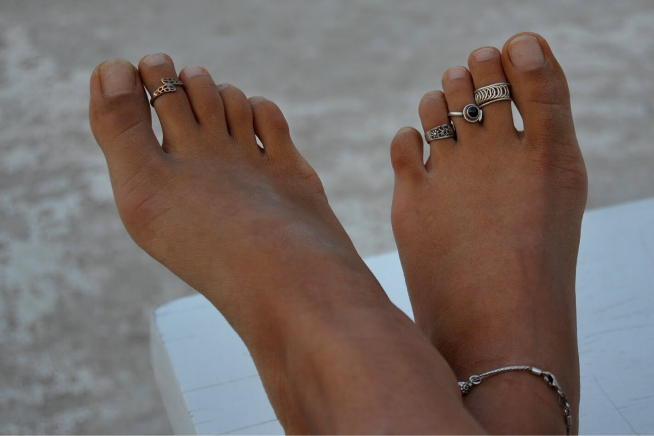 Женские пальцы на ногах с кольцами